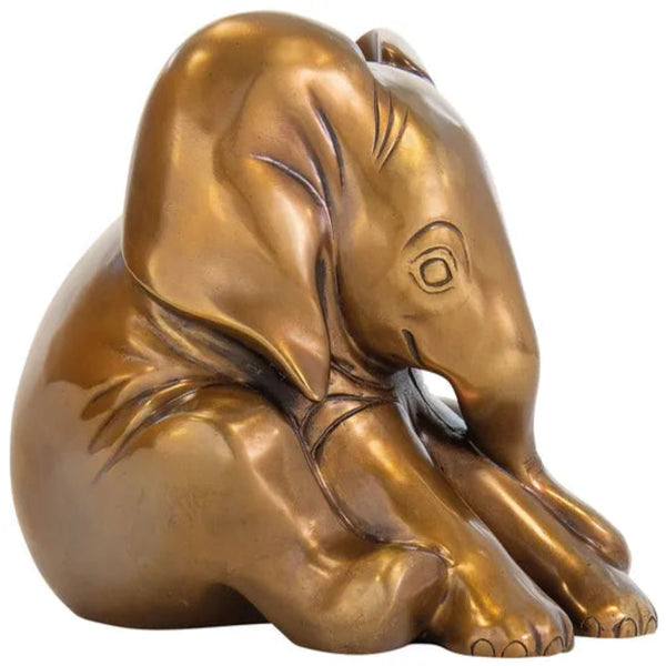Bronzeskulptur eines sitzenden Elefantenbabys, dessen Rüssel zum Boden gebogen ist.