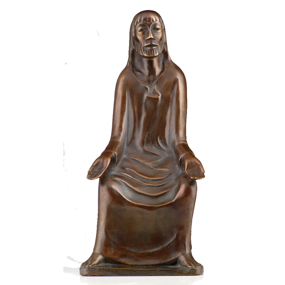 Ernst Barlach: Skulptur „Lehrender Christus“, Reduktion in Bronze zeigt eine sitzende Figur mit langem Haar und Gewand, die Hände offen im Schoß, vor weißem Hintergrund.