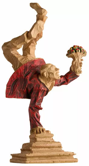 Roman Johann Strobl: „Alles Gute“, Kunstguss Holzfinish – Holzstatue eines Affen in roter Jacke, der auf einer Hand balanciert und einen Obststrauß hält.