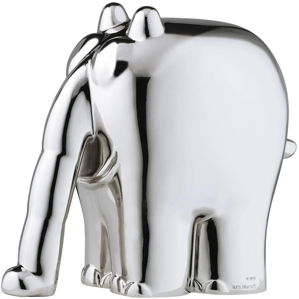 Silberglänzende Elefantenfigur, die mit gesenktem Rüssel steht.