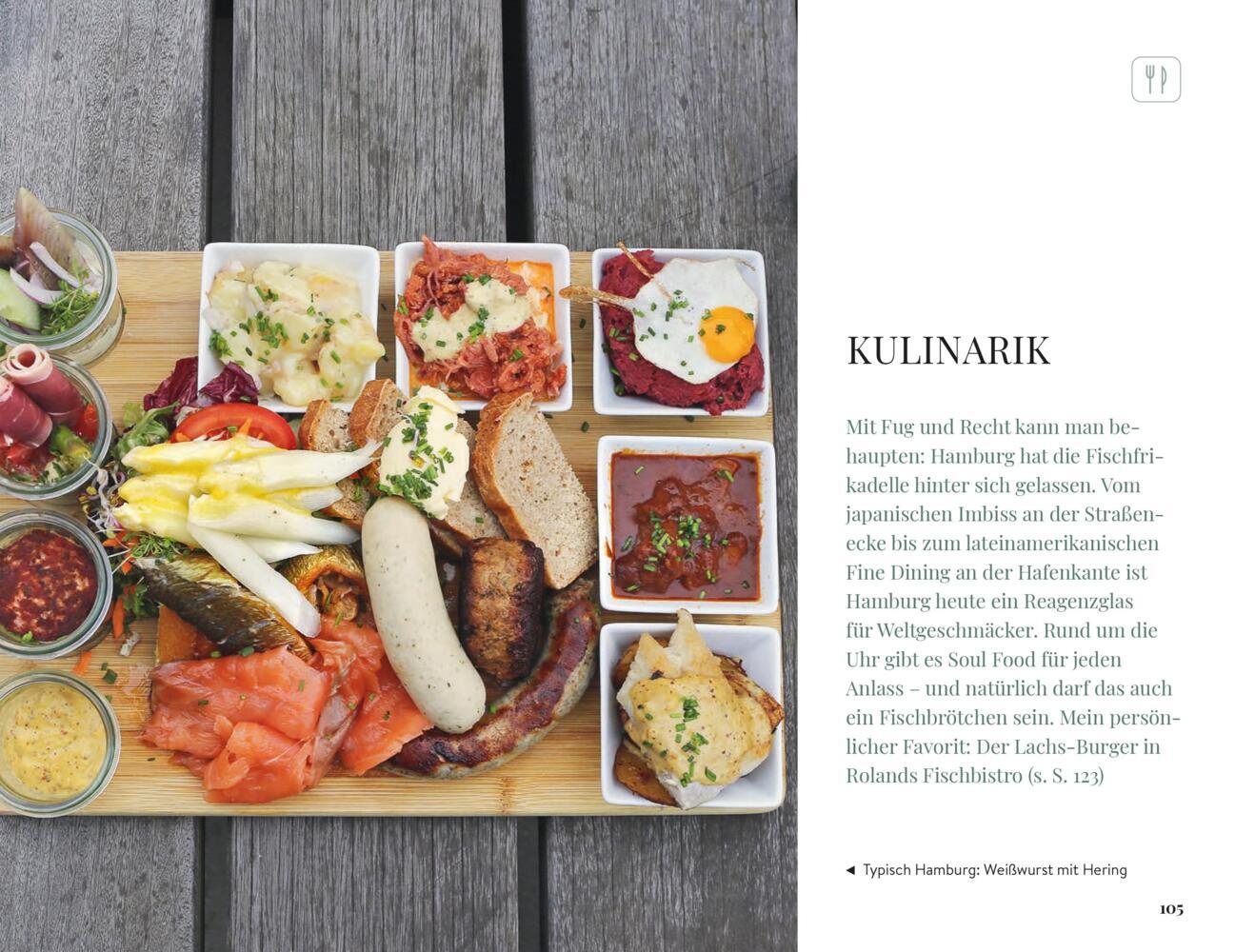 Eine Holztafel mit verschiedenen Vorspeisen, Brot, Dips, Meeresfrüchten und Salat, die auf einem weißen Tisch steht.