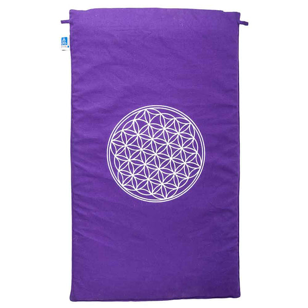 Eine violette rechteckige Matte mit einem weißen geometrischen Lebensblumenmuster in der Mitte.