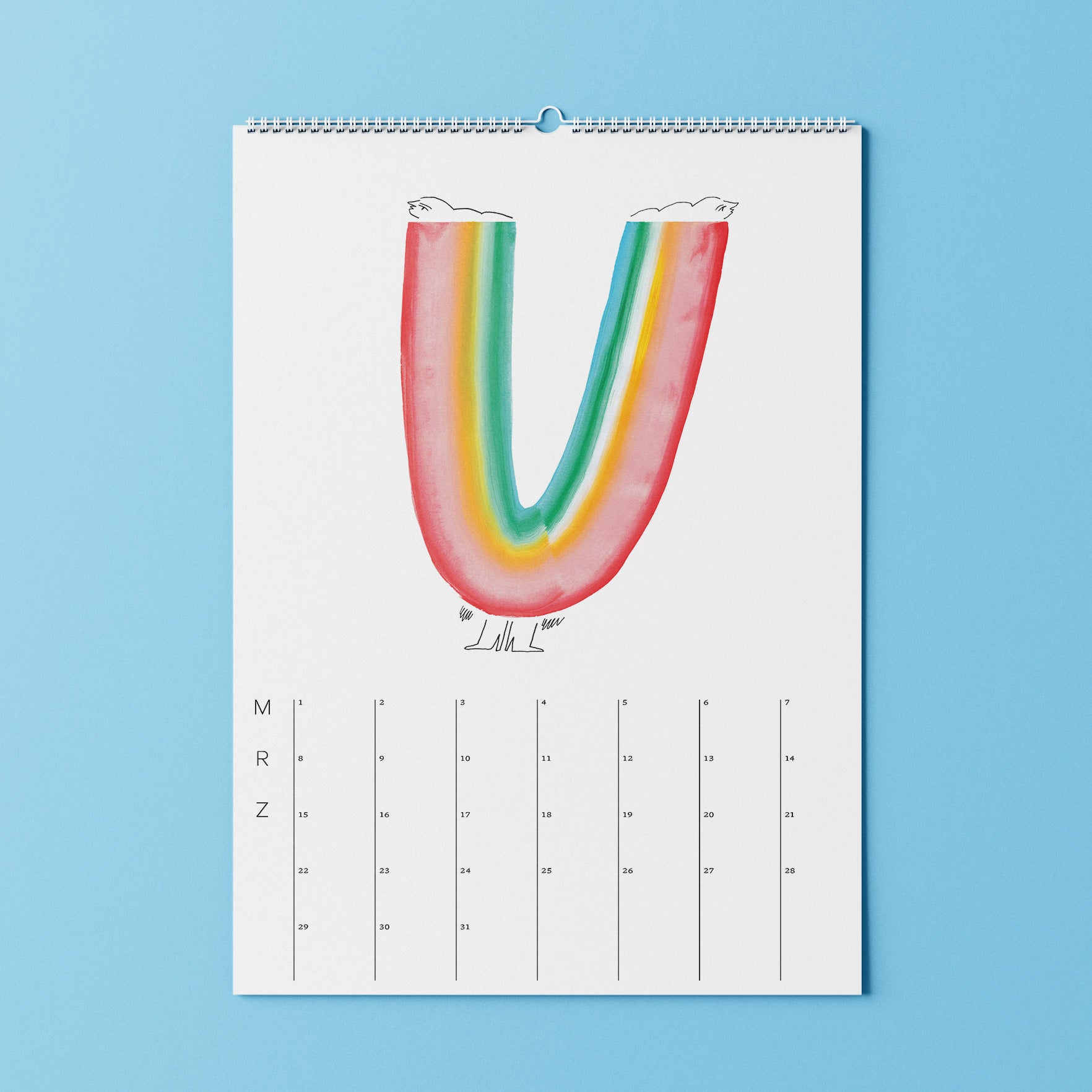 Ein Wandkalender mit einer farbenfrohen Regenbogenillustration des Buchstabens U auf blauem Hintergrund.