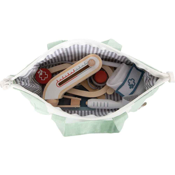 Draufsicht auf eine grüne Tasche mit gestreiftem Futter, die medizinische Spielzeuginstrumente aus Holz enthält, darunter ein Thermometer und eine Spritze.