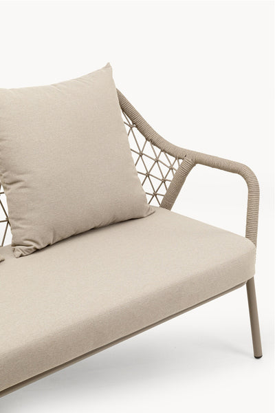 Beigefarbenes Outdoor-Sofa mit großem Kissen, seilumwickelter Armlehne und Rückenlehne mit Kreuzmuster auf weißem Hintergrund.