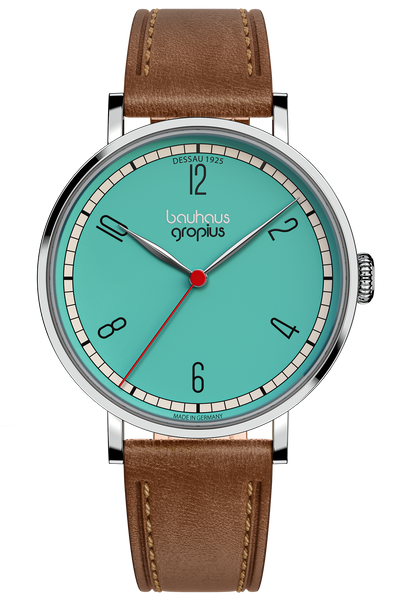 Eine Armbanduhr mit türkisfarbenem Zifferblatt, schwarzen Ziffern, rotem Sekundenzeiger, silbernem Gehäuse und braunem Lederband. Das Zifferblatt ist mit "bauhaus gropius" beschriftet.