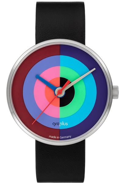 Eine Armbanduhr mit schwarzem Lederarmband und einem runden Zifferblatt mit konzentrischen bunten Ringen und silbernen Zeigern; unten ist "gropius made in Germany" aufgedruckt.