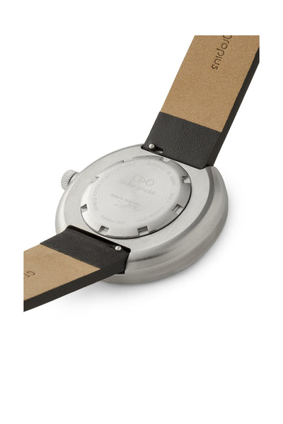 Nahaufnahme der Rückseite einer Armbanduhr mit einem Gehäuse aus Edelstahl und einem schwarzbraunen Lederarmband. Auf dem Gehäuseboden sind Text und Markendetails eingraviert.