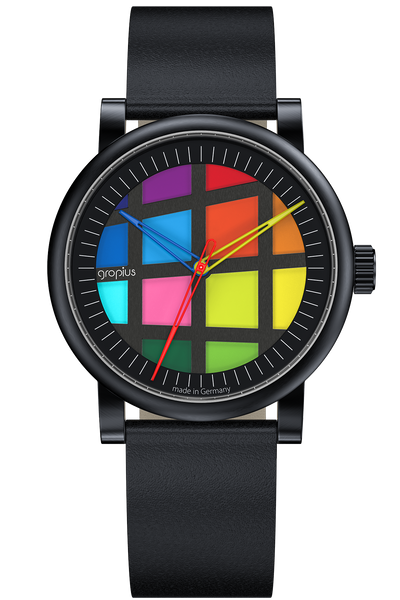 Eine Armbanduhr mit schwarzem Lederarmband, schwarzem Gehäuse und einem farbenfrohen Gittermuster auf dem Zifferblatt, das anstelle der traditionellen Stundenmarkierungen verschiedene helle Quadrate aufweist.