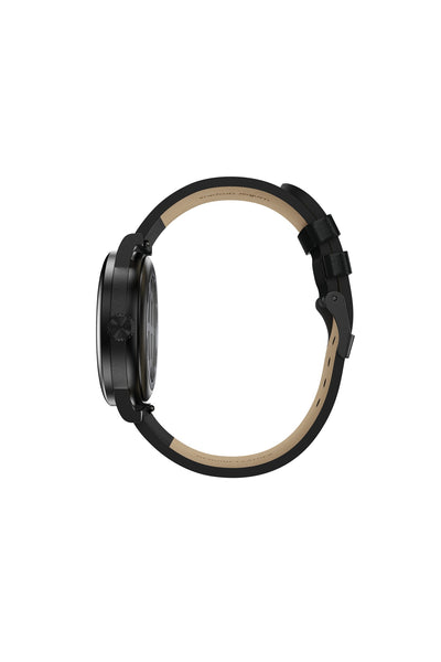 Seitenansicht einer schwarzen Armbanduhr mit rundem Zifferblatt, schwarzer Lünette und schwarzem Schnallenarmband vor einem schlichten weißen Hintergrund.