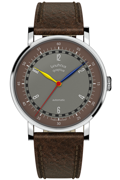 Eine Armbanduhr mit braunem Lederarmband, grauem und braunem Zifferblatt, weißen Stundenmarkierungen und roten, gelben und blauen Zeigern. Auf dem Zifferblatt steht bauhaus gropius automatic.