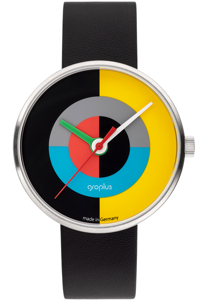 Eine Armbanduhr mit schwarzem Lederarmband und einem bunten, geometrischen Zifferblatt mit Segmenten in Schwarz, Gelb, Blau, Grau und Rot, mit weißer Aufschrift "gropius" und silbernem Gehäuse.