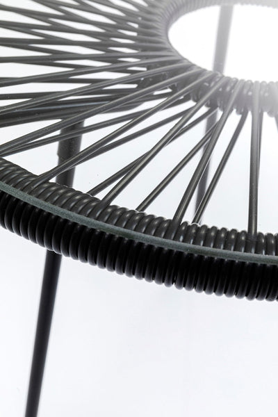 Nahaufnahme einer runden Glastischplatte, die von einem Metallrahmen mit schwarzen Drahtspeichen getragen wird, die strahlenförmig von der Mitte ausgehen.