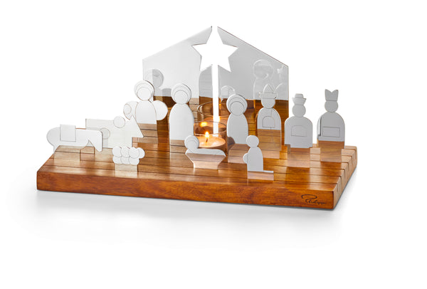 Moderne Krippe aus Metall und Holz mit Figuren und einer Kerze auf einem Holzsockel.