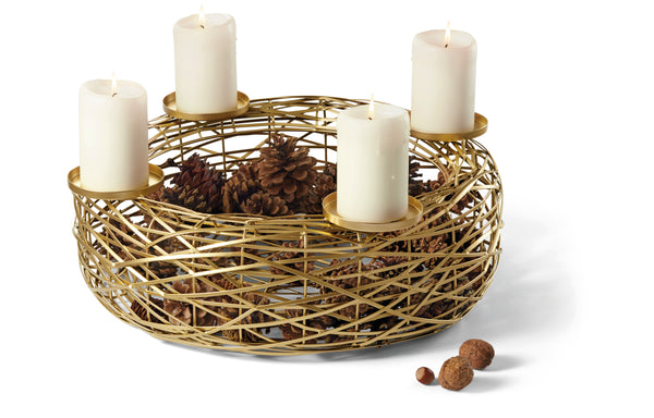 Ein goldener Drahtkorb enthält Tannenzapfen und vier brennende weiße Stumpenkerzen auf goldenen Haltern am Rand.