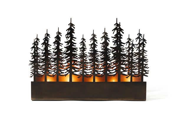 Waldsilhouetten-Kerzenhalter aus Metall mit brennenden Kerzen im Inneren, die an hohe Tannenbäume vor einem weißen Hintergrund erinnern.