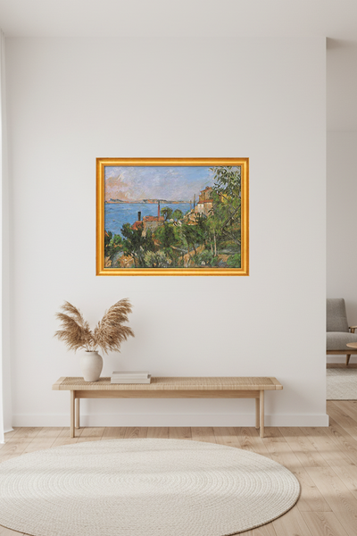 Ein gerahmtes Gemälde zeigt eine Küstenlandschaft mit blauem Wasser, grüner Vegetation, Häusern und einem teilweise bewölkten Himmel - an einer Wand im Wohnzimmer hängend. 
