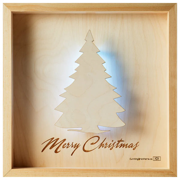 Holzkunstwerk mit ausgeschnittenem Weihnachtsbaum und darunter eingraviertem Merry  Christmas, in einem Holzrahmen.