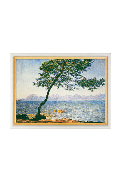 Gerahmtes Gemälde eines einsamen Baumes am Ufer, mit einem Gewässer und fernen Bergen unter blauem Himmel.