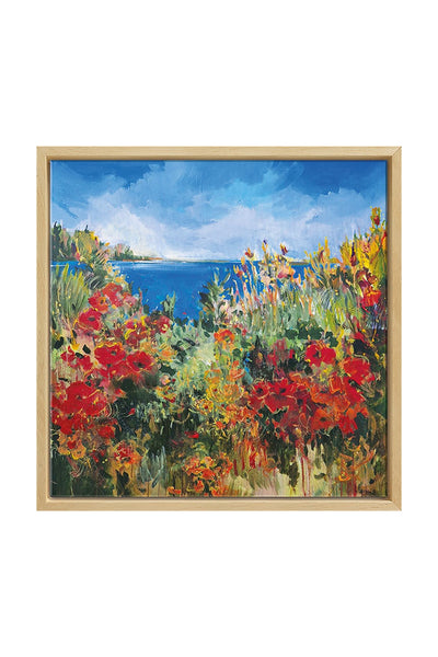 Gerahmtes Gemälde einer lebendigen Küstenlandschaft mit roten Blumen, grünem Laub und einem blauen Himmel über einem Gewässer.