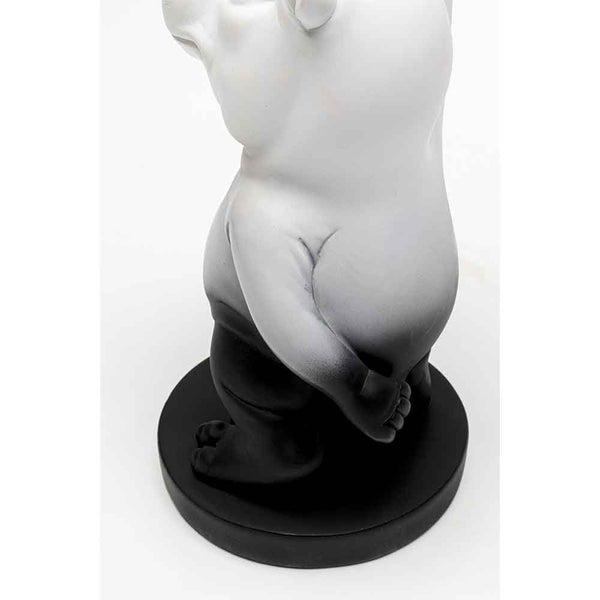 Eine schwarz-weiße Bärenfigur steht auf einem runden schwarzen Sockel, von der Seite gesehen.