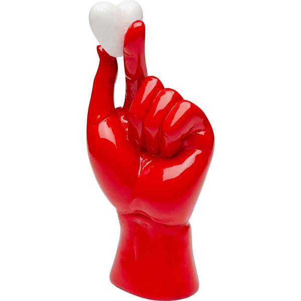 Eine glänzend rote Handskulptur hält ein kleines weißes Herz zwischen ihren Fingern.