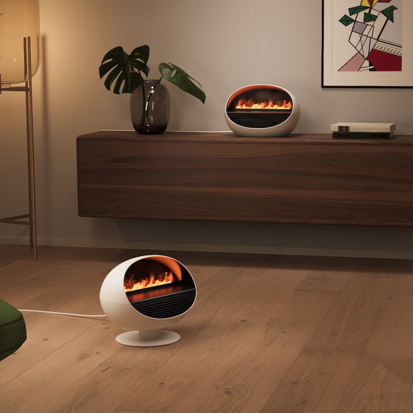 Zwei runde, moderne Heizstrahler mit einer Feuerattrappe, einer auf dem Boden und einer auf einem Holzschrank.