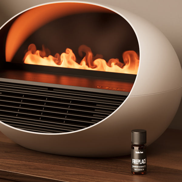 Moderner weißer Elektrokamin mit sichtbaren Flammen, daneben eine kleine Flasche mit der Aufschrift "Fireplace" auf einer Holzfläche.