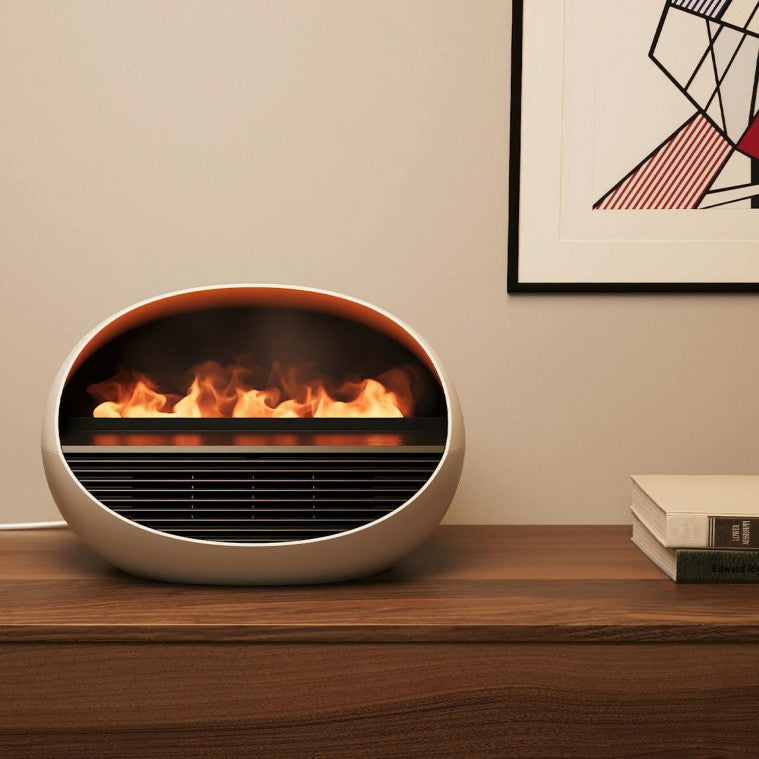 Ein runder elektrischer Ofen auf einem Holztisch, der so gestaltet ist, dass er aussieht, als ob er realistische Flammen enthält.