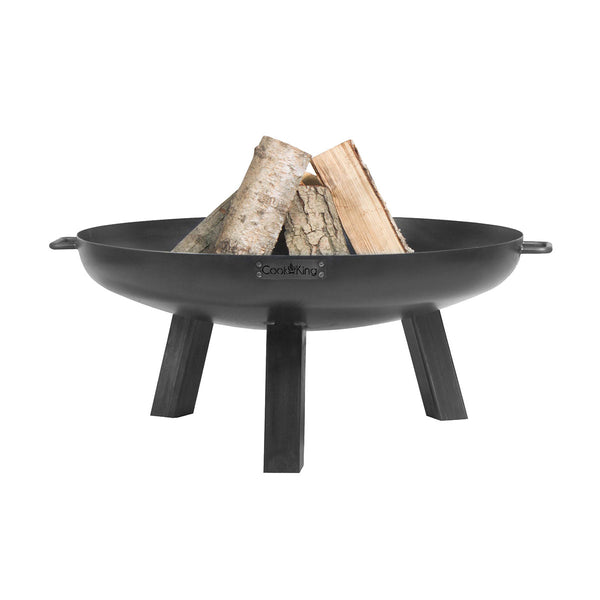 Eine schwarze Metallfeuerstelle mit Holzscheiten im Inneren, die auf drei stabilen Beinen steht.