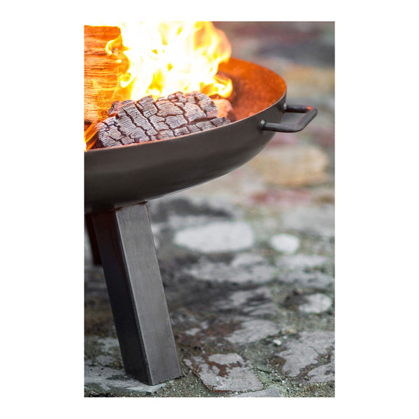 Nahaufnahme einer Feuerstelle mit brennendem Holz und glühender Glut auf einer Steinoberfläche.