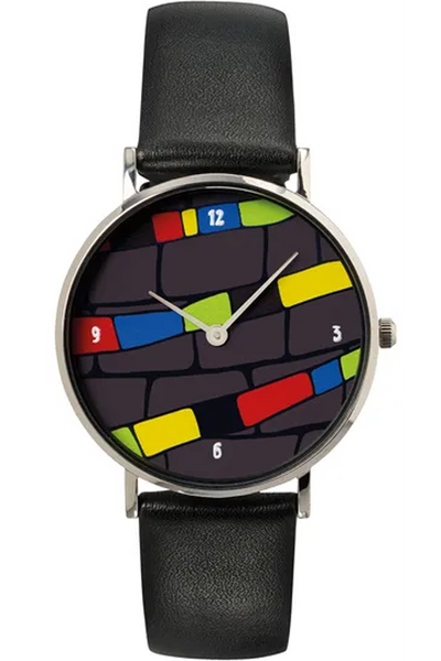 Eine Uhr mit schwarzem Lederarmband und hundertwassertypischem Ziffernblatt, bestehend aus bunten gelb, grün, rot und blauen Streifen und schwarz grauen Streifen. 