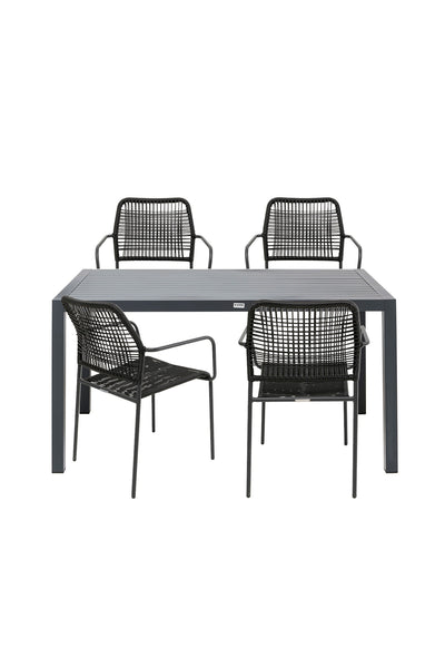 Ein rechteckiger grauer Tisch mit vier schwarzen geflochtenen Stühlen, die um ihn herum angeordnet sind, zwei auf jeder Seite, vor einem schlichten weißen Hintergrund.