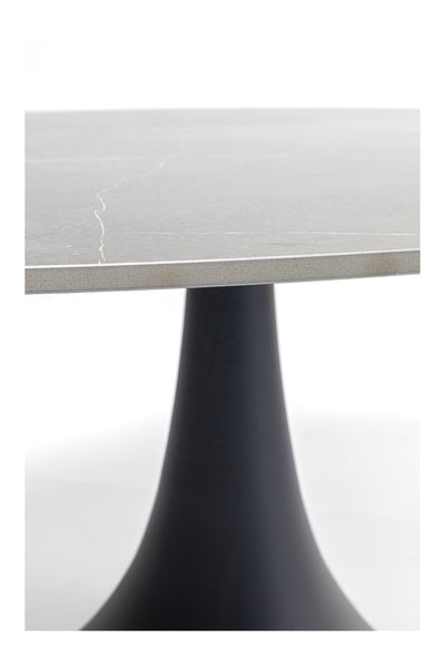 Runder Tisch mit einer dünnen, hellgrauen Steinplatte mit dezenter weißer Maserung, getragen von einem schwarzen, kegelförmigen Sockel.
