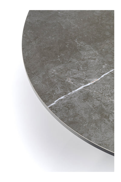 Nahaufnahme einer runden, grauen Marmortischplatte mit einer sichtbaren weißen Ader, die diagonal über die Oberfläche verläuft.