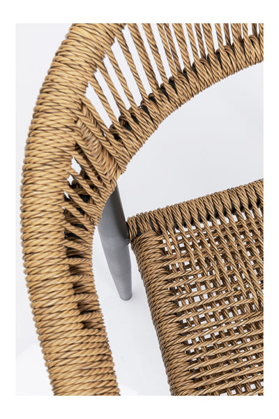 Nahaufnahme eines geflochtenen Rattanstuhls, die das detaillierte Flechtmuster auf Sitz und Rückenlehne zeigt, wobei ein Bein auf weißem Hintergrund sichtbar ist.