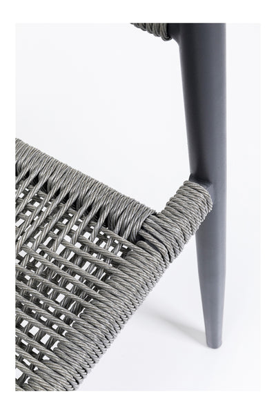 Nahaufnahme einer Stuhlecke mit Sitz und Rückenlehne aus grauem Seilgeflecht auf einem dunkelgrauen Metallrahmen vor weißem Hintergrund.