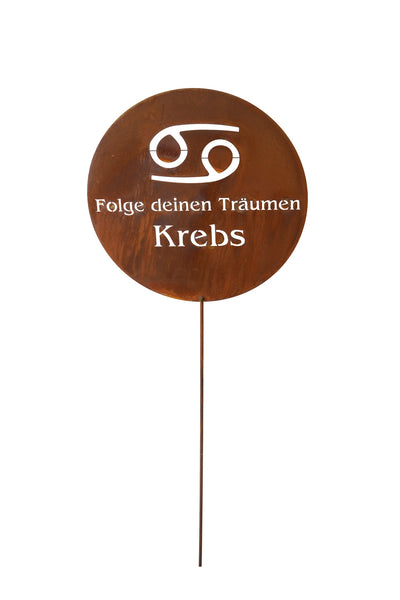 Ein rundes Metallschild mit dem Tierkreiszeichen Krebs, dem deutschen Text Folge deinen Träumen Krebs und einem langen Pflanzstab.