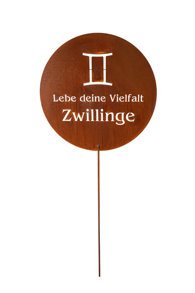 Ein rundes Metallschild mit dem Tierkreiszeichen der Zwillinge und dem deutschen Text Lebe deine Vielfalt Zwillinge auf weißem Hintergrund.