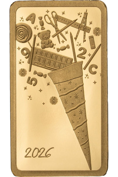 Goldbarren mit dem eingravierten Bild einer Schultüte, die Schulsachen, Süßigkeiten und Zahlen ausspuckt, mit der Inschrift 2026 am unteren Rand.