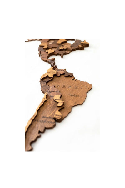 Eine Holzkarte, die Südamerika mit eingravierten Ländernamen wie Brasilien und Argentinien darstellt.