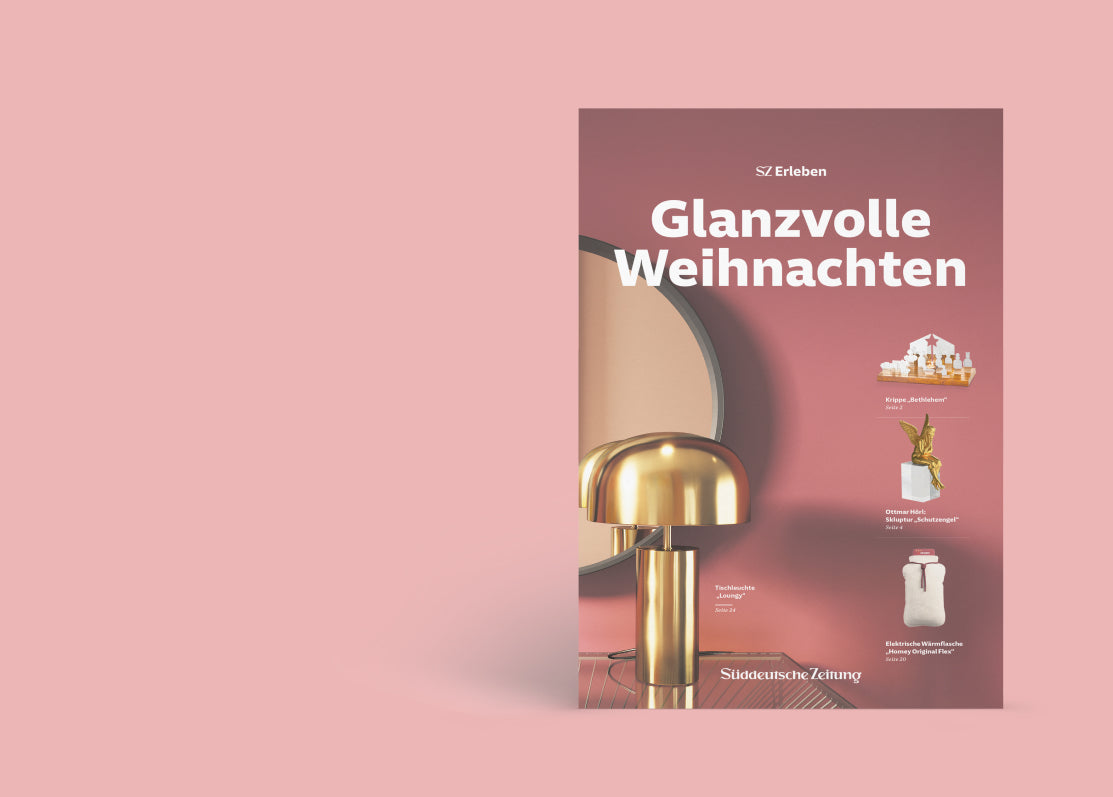 Geschenkebeilage mit goldener Tischlampe, eine Krippe, Skulptur mit einem goldenen Engel und beiger Wärmflasche.