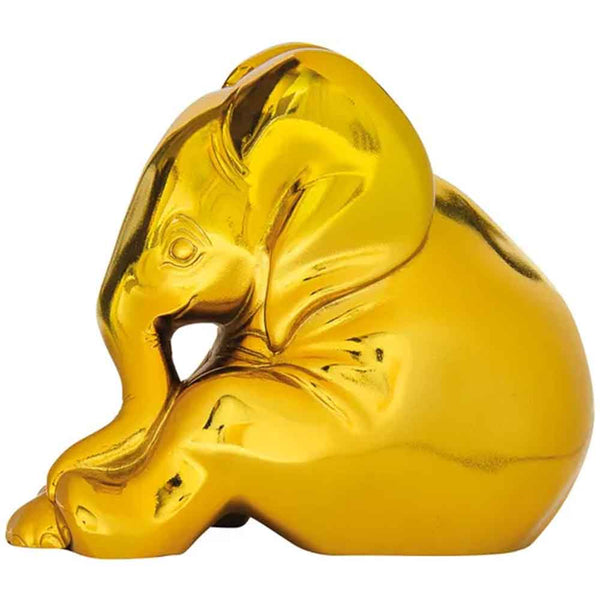 Goldglänzende Skulptur eines sitzenden, ruhenden Elefanten mit nach innen gebogenem Rüssel.