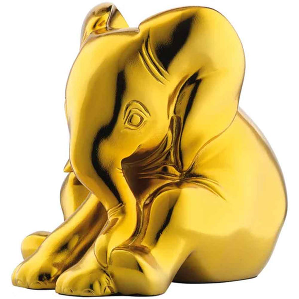 Eine glänzende, goldfarbene Elefantenfigur, die mit nach vorne gerolltem Rüssel sitzt.