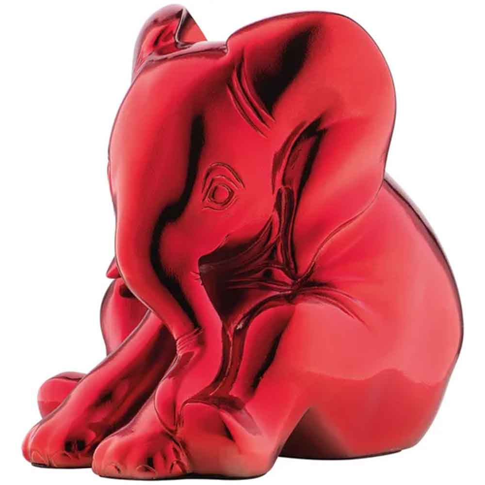 Eine leuchtend rote Elefantenfigur, die mit ihrem Rüssel zwischen den Vorderbeinen sitzt.