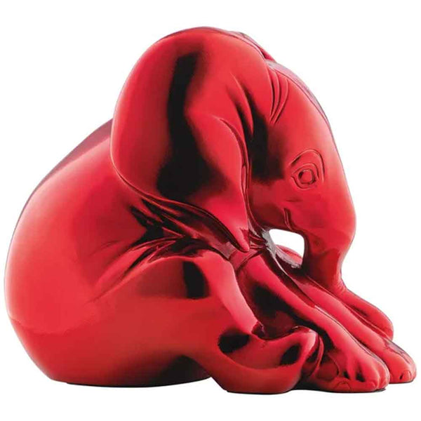 Glänzende rote Elefantenfigur, die mit gesenktem Kopf sitzt und den Rüssel auf die Vorderbeine stützt.