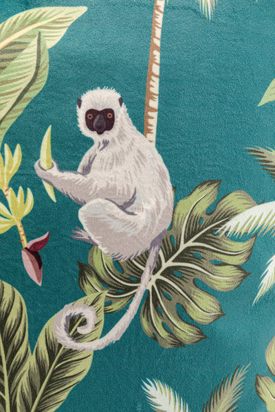 Illustration eines weißen Lemurs, der auf einem tropischen Blatt vor einem blaugrünen Hintergrund mit Palmenblättern sitzt.