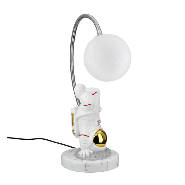 Tischleuchte mit weißem Astronauten, der eine goldene Kugel hält, darüber eine runde Lichtkugel auf einem Marmorsockel.