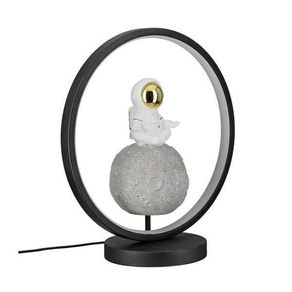 Eine runde Lampe mit einer kleinen Astronautenfigur, die auf einem mondähnlichen Sockel im Inneren des Rings sitzt.