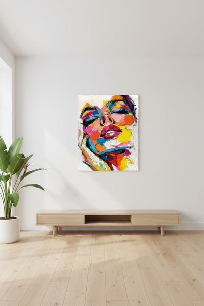 Ein minimalistisches Wohnzimmer mit einem hölzernen TV-Ständer, einer grünen Topfpflanze und einem farbenfrohen abstrakten Porträt eines Frauengesichts an einer weißen Wand.